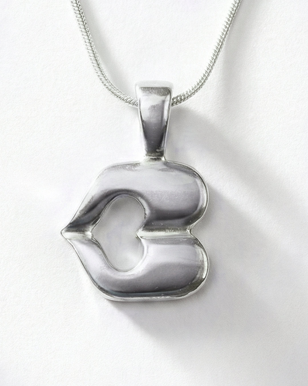 Silver letter B pendant on a white background