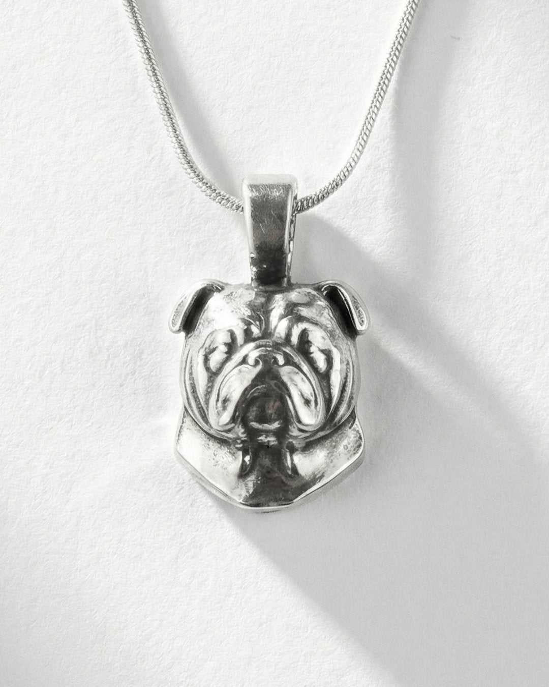 Silver bulldog pendant necklace on a white background