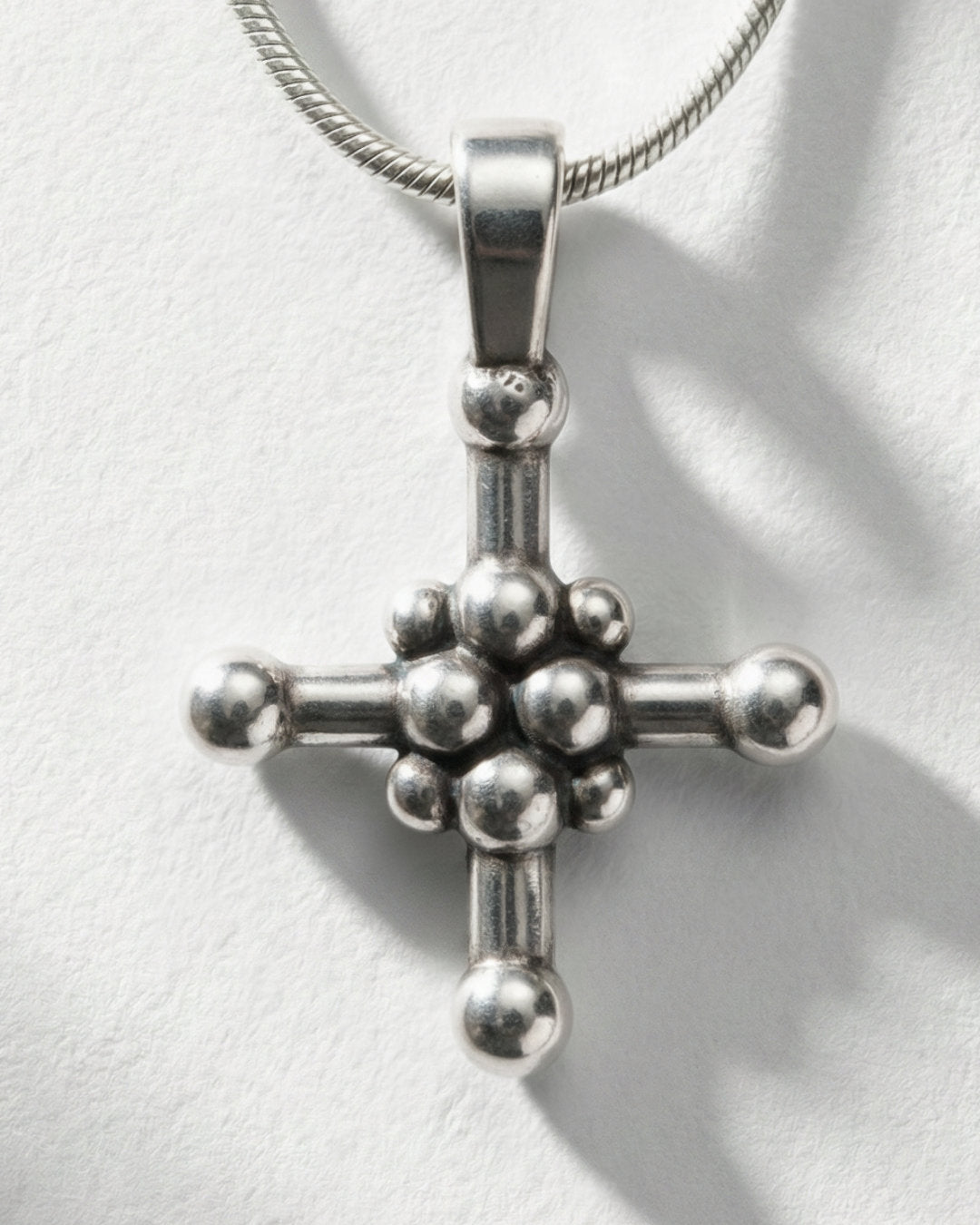 Dot Cross pendant worn, silver with snake chain