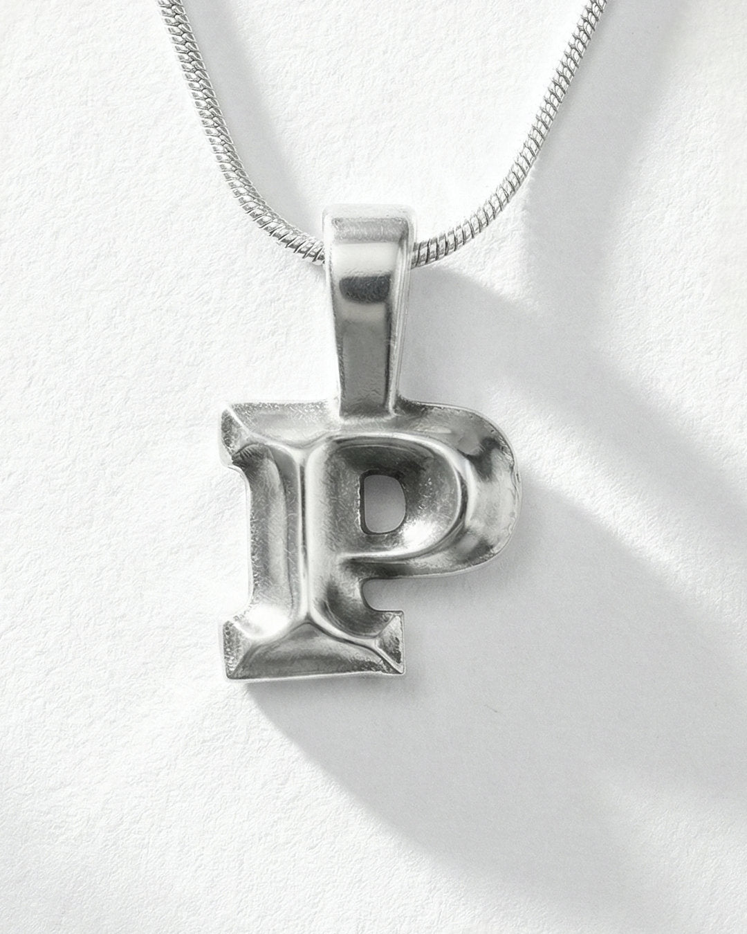 Silver letter 'P' pendant on a white background